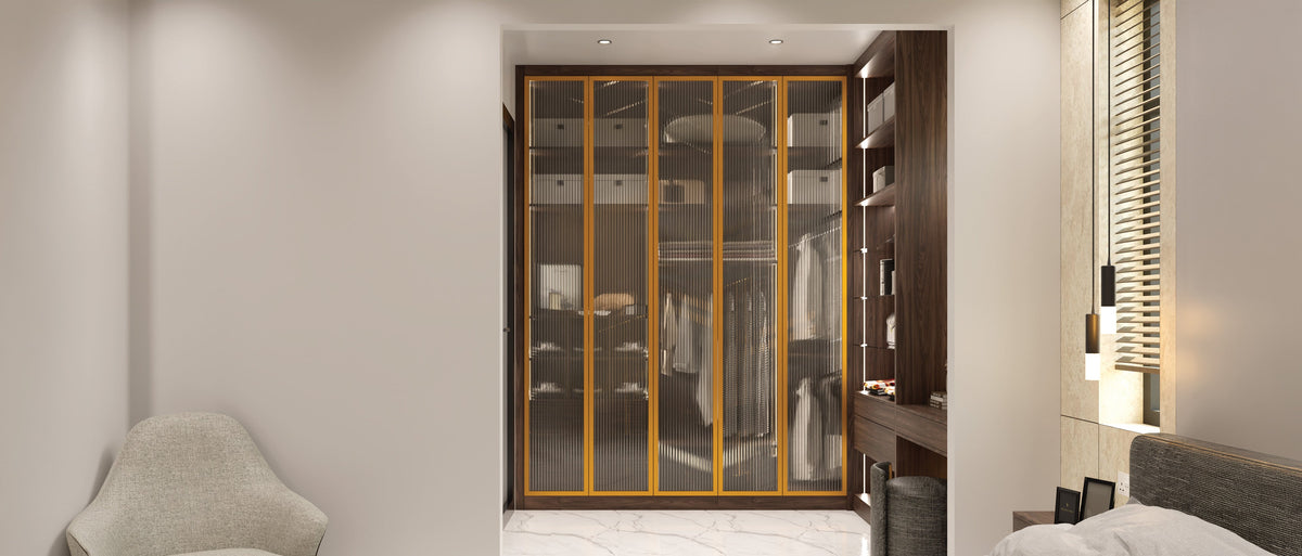 Brass aluminium-framed fluted glass wardrobe doors over a lit walnut interior, made to measure in London