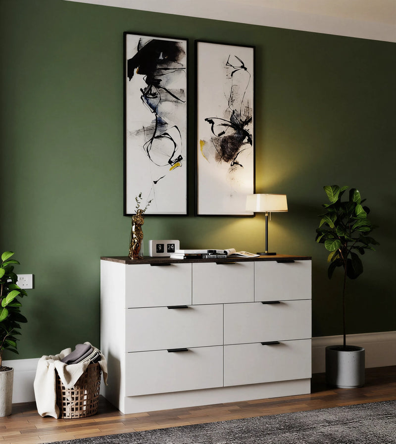 Greenwich seven-drawer chest in white with a walnut top and black handles against a green wall