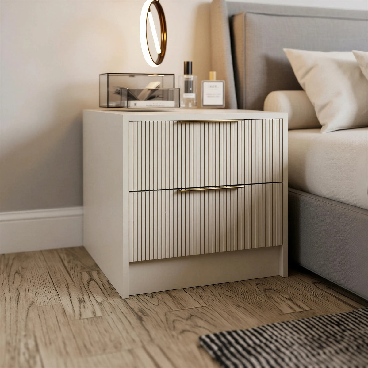 Marlow fluted bedside: a cream two-drawer bedside with fluted fronts and brass bar handles beside an upholstered bed