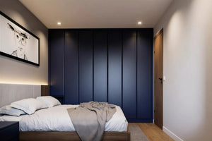 Modern fitted wardrobes around a bed — Oslo doors in deep blue