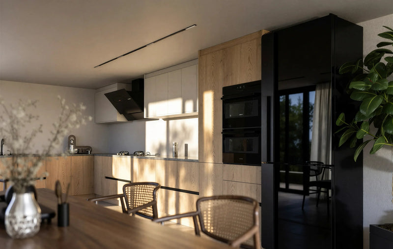 Shoreditch Oak Handleless Kitchen in London: light oak woodgrain handleless doors with a dark grey stone worktop, black tall units and a walnut dining table; the black tall unit bank with ovens and fridge-freezer beside the dining table. Made to measure by Metro Home Interiors