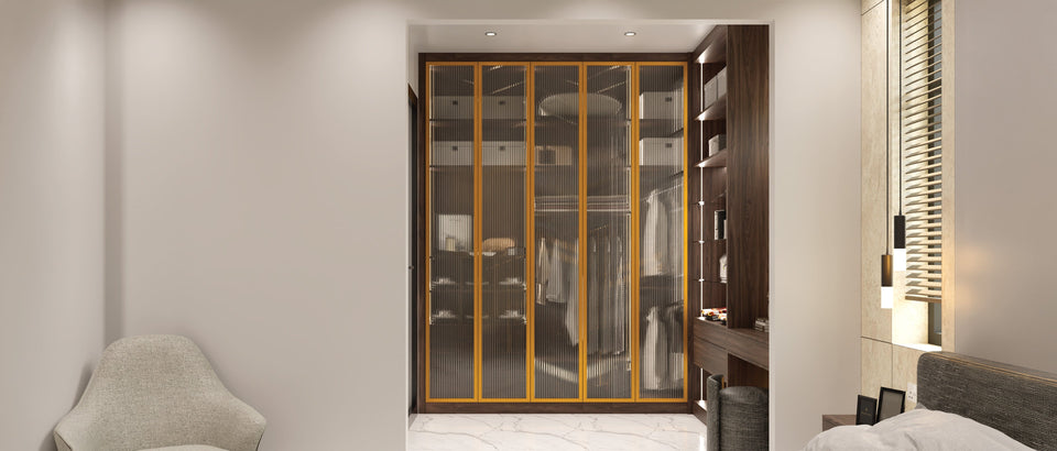 Brass aluminium-framed fluted glass wardrobe doors over a lit walnut interior, made to measure in London