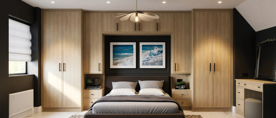 Light oak solid timber fitted wardrobes around a bed with a picture recess and bedside drawers, made to measure in London