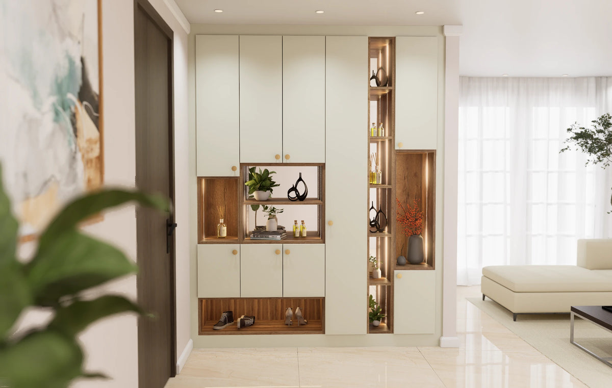Albany fitted foyer unit in London: floor-to-ceiling cream slab hallway cupboards with brass knobs, oak-lined lit display niches, a tall lit shelf column and an open lit shoe bay along the floor beside the front door. Made to measure by Metro Home Interiors in Wembley.