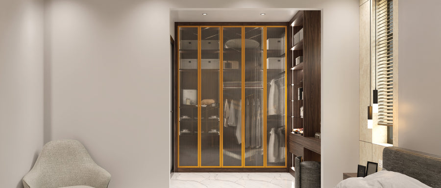 Brass aluminium-framed fluted glass wardrobe doors over a lit walnut interior in a bedroom, made to measure in London