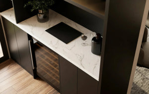 Carlton Bar Unit in London: a charcoal handleless home bar with a white marble worktop, lit shelving, glazed cabinets and a wine cooler; the white marble worktop and wine cooler up close. Made to measure by Metro Home Interiors