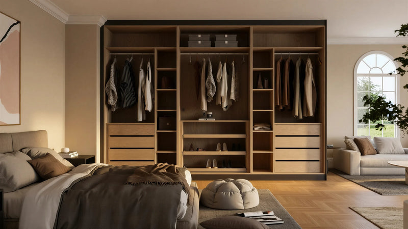 Cordelia fitted bedroom furniture in London: dark walnut sliding wardrobe doors with a mirror panel and brass handles; the walnut sliding wardrobe open to hanging, shelves and drawers. Made to measure by Metro Home Interiors