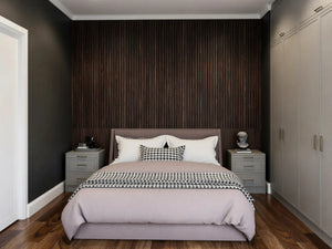 Gladstone MDF painted fitted wardrobe in London: warm grey in-frame slab doors with brass bar handles, wardrobes either side of the bed with matching bedside chests against a dark slatted wall, made to measure by Metro Home Interiors