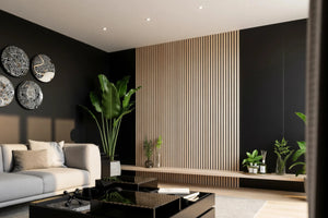 Hertford oak slatted TV wall panel in London, close up: the pale oak slats and the long floating oak shelf with plants and glassware on the charcoal wall. Made to measure by Metro Home Interiors