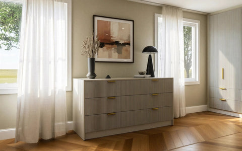 Chest of drawers: a cream fluted chest of drawers under a window