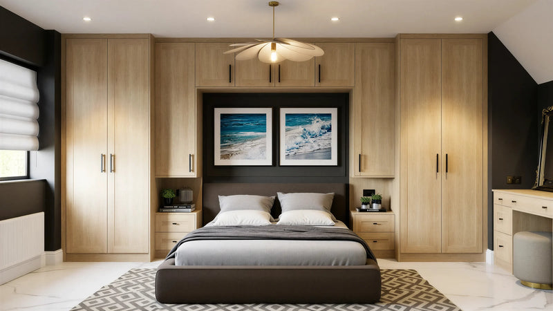 Monroe Oak fitted wardrobes in London: natural sanded solid oak Monroe Oak shaker doors with black bar handles, wrapping the bed with over-bed storage, bedside chests and a dressing table