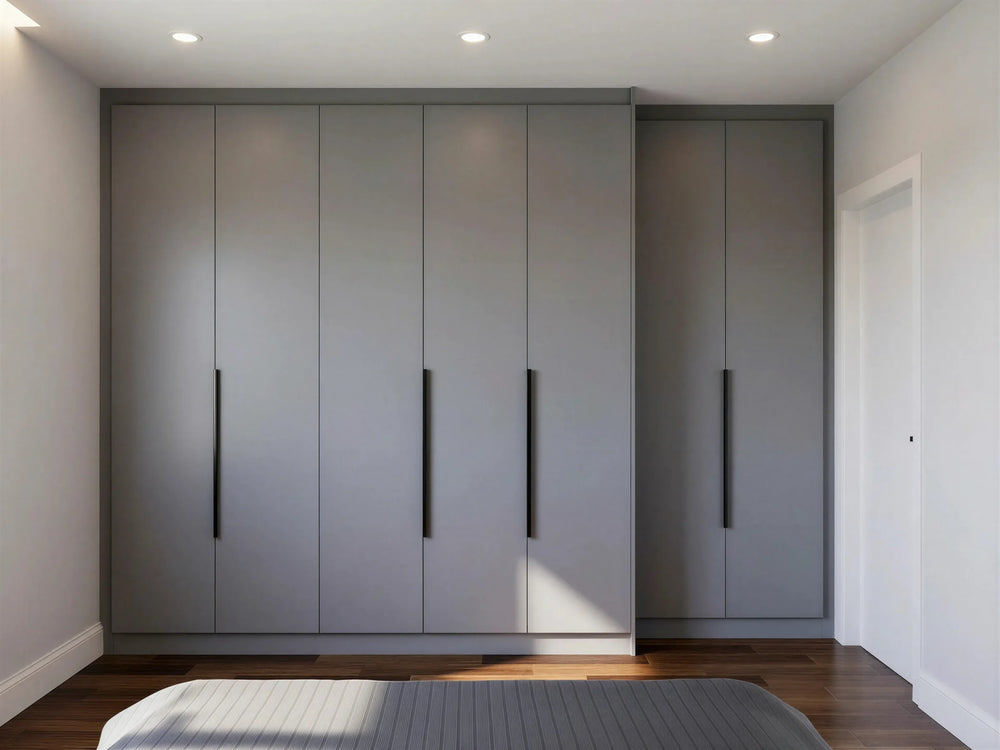 Ophelia fitted bedroom furniture in London: dove grey handleless wardrobe wall with recessed grip rails; the floor-to-ceiling handleless wardrobe wall beside the bed. Made to measure by Metro Home Interiors