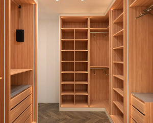 Regents Park walk-in wardrobe in London, third view with the doors open: walnut shoe shelving, hanging and drawers on three walls of the dressing room. Made to measure by Metro Home Interiors