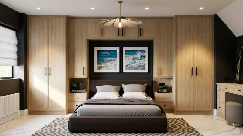 Brooklyn Oak fitted wardrobes in London: natural sanded solid oak Brooklyn Oak doors with black bar handles, wrapping the bed with over-bed storage, bedside chests and a dressing table